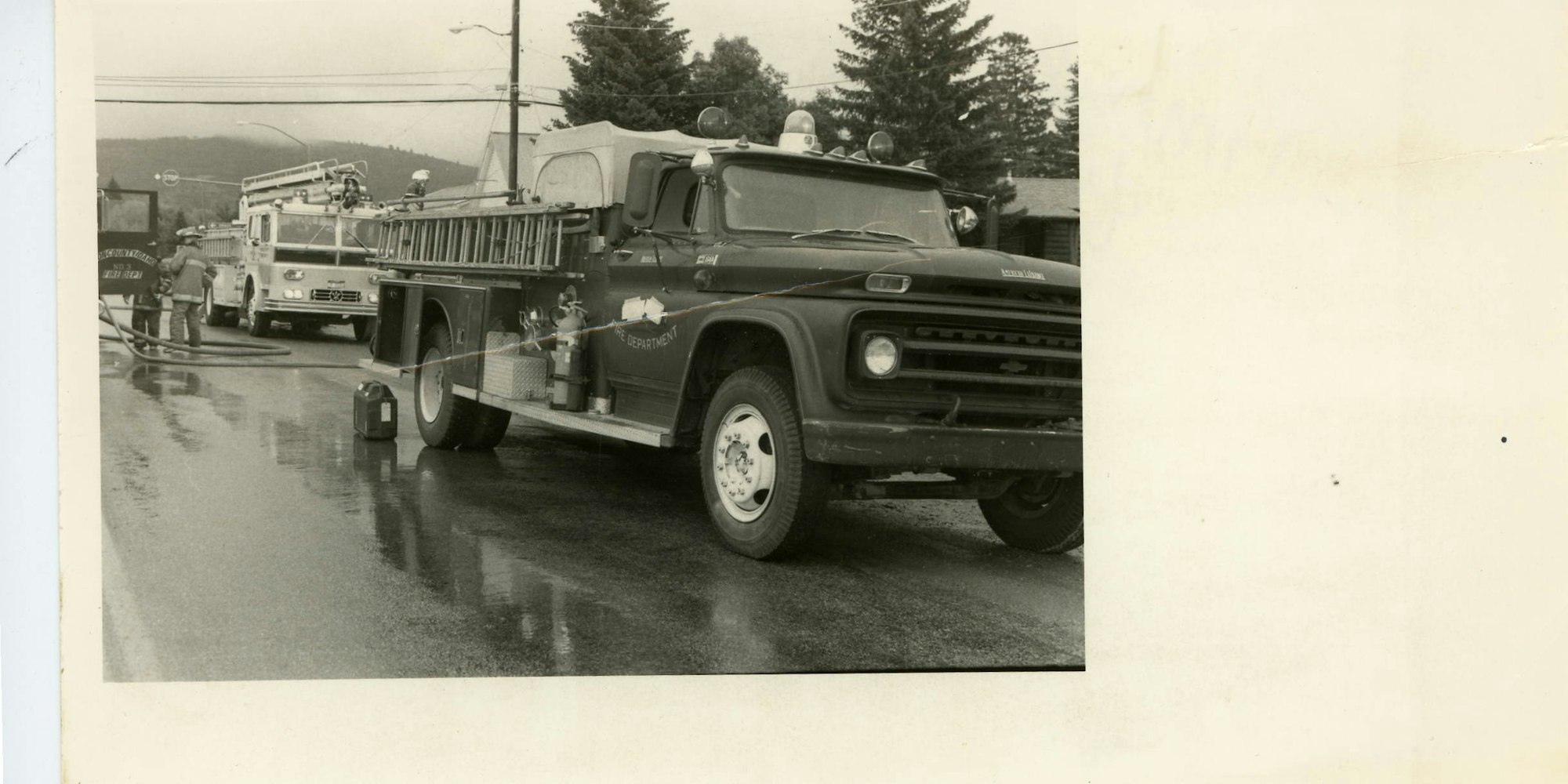 Vintage photo of fire trucks and firefighters in action.