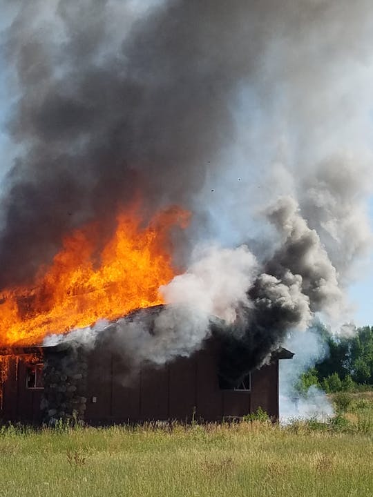 A building engulfed in flames with thick smoke rising.