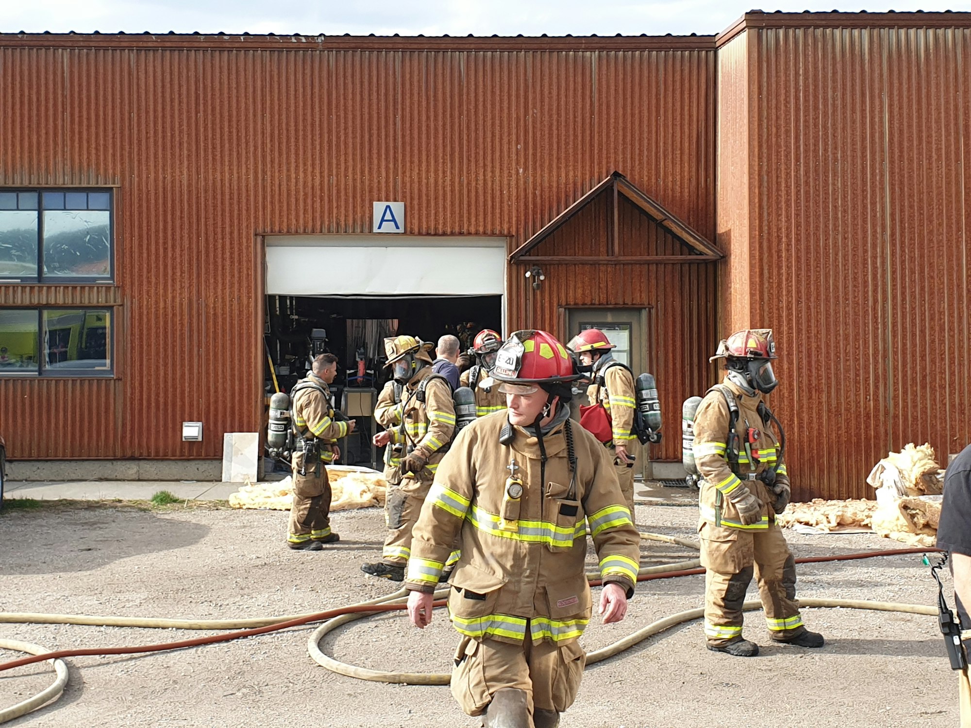 Firefighters with gear outside a building, possibly post-training or emergency.