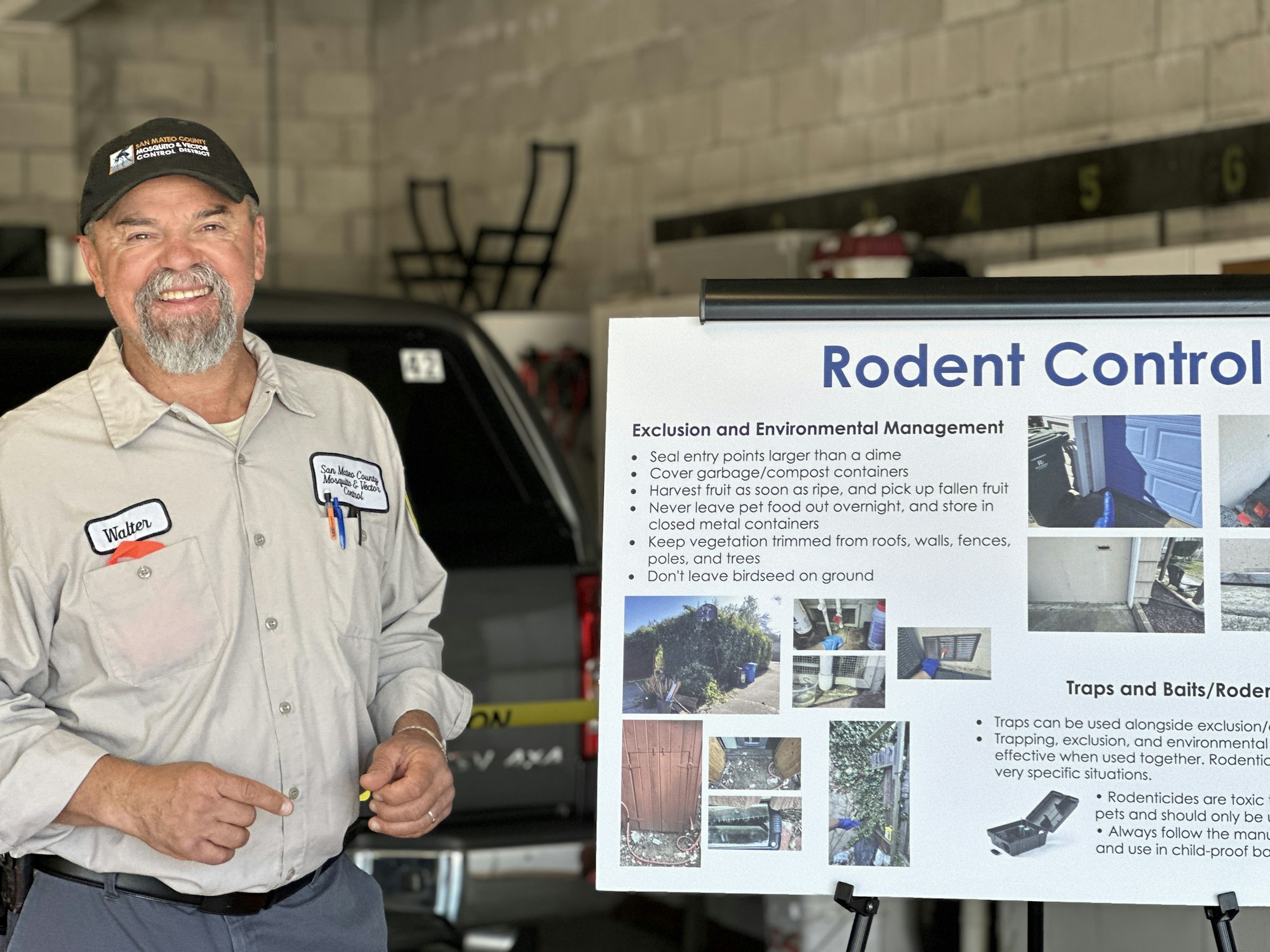 A person stands next to a rodent control information board discussing exclusion and environmental management tips.