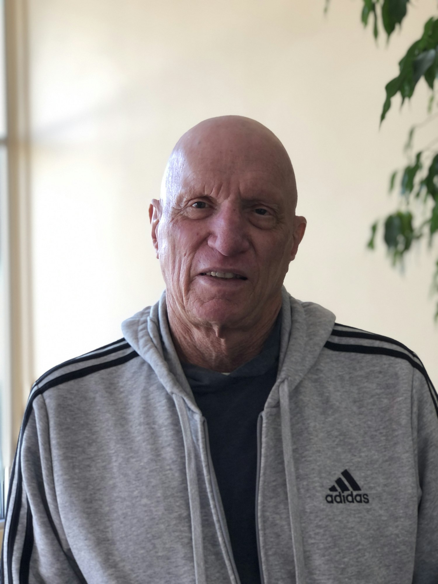 Photo of man looking at camera wearing grey sweatshirt