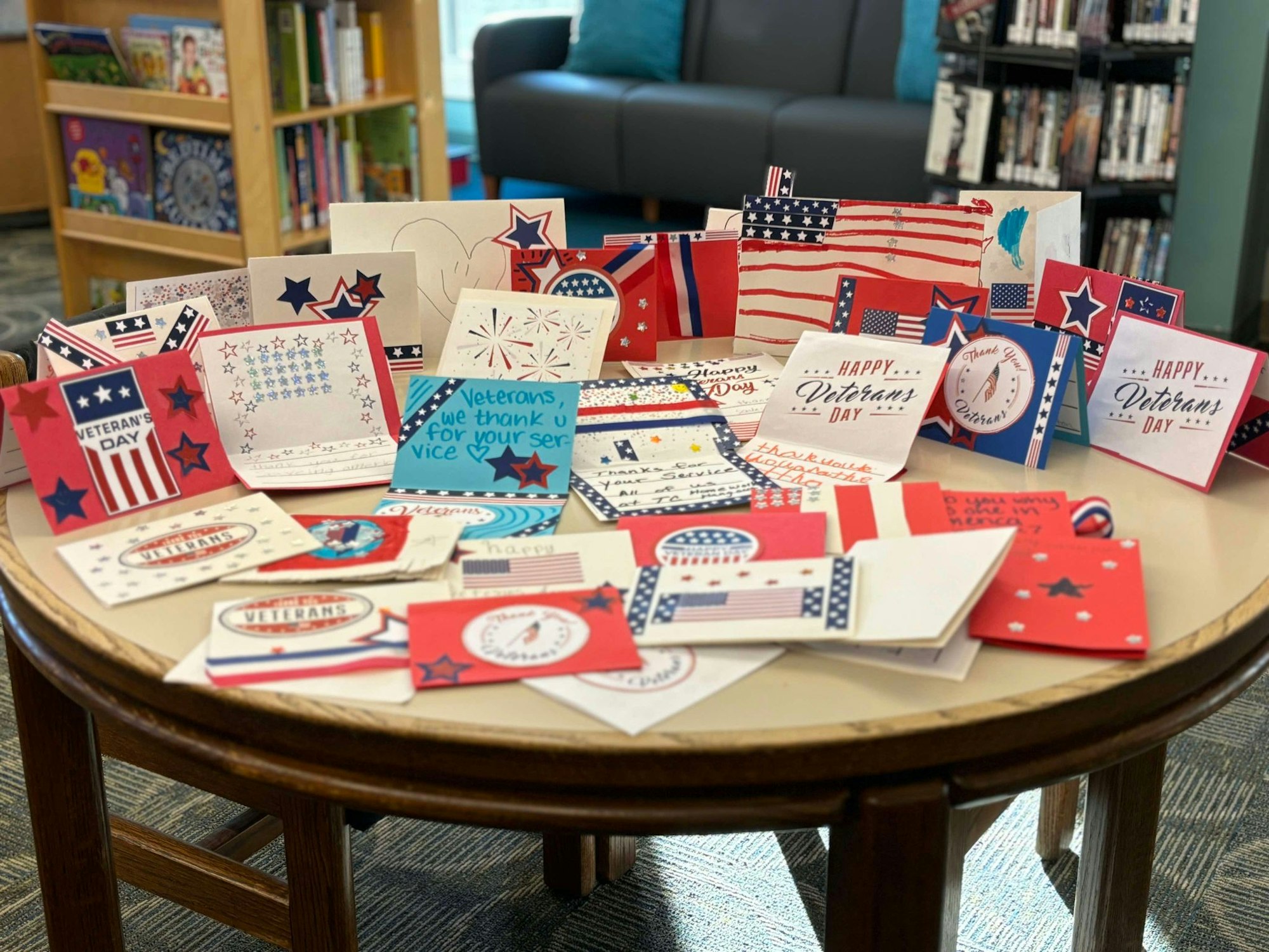 A collection of handmade cards celebrating Veterans Day, with patriotic designs, displayed on a table.