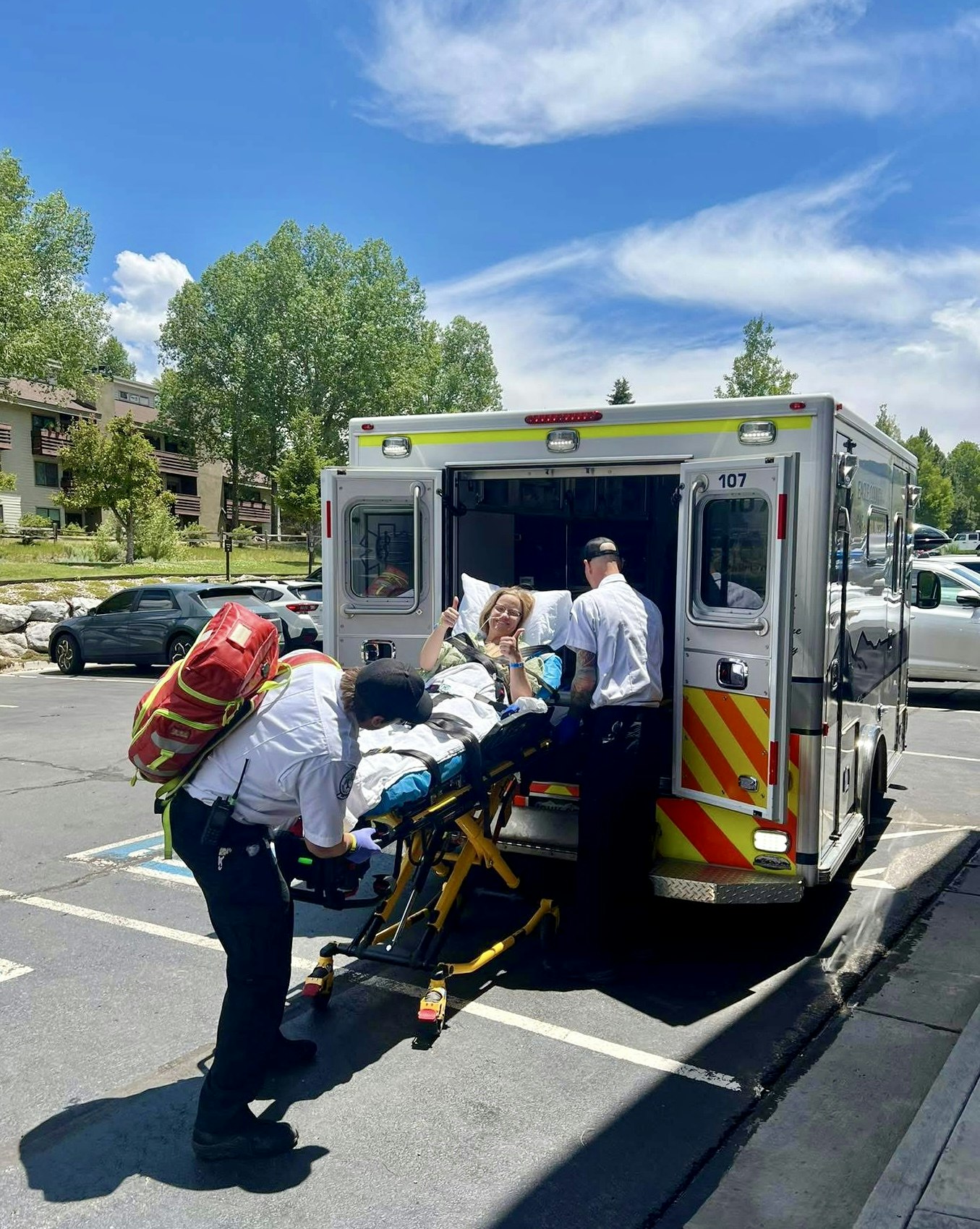 A person on a stretcher being placed into an ambulance by emergency responders.