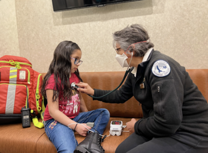 Photo of paramedic listening to a child's heart with a stethoscope