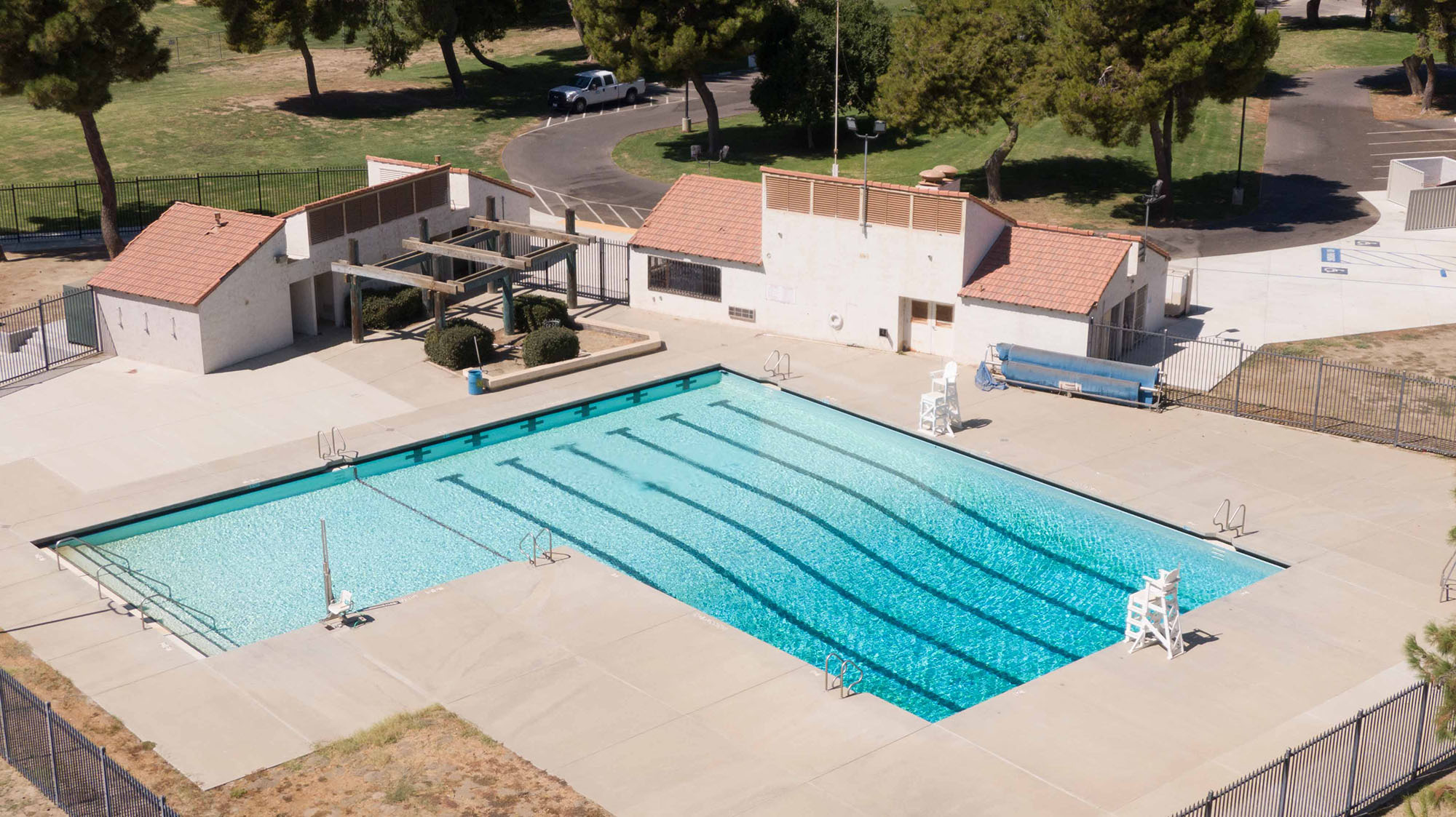 Aerial view of an outdoor swimming pool with surrounding facilities.