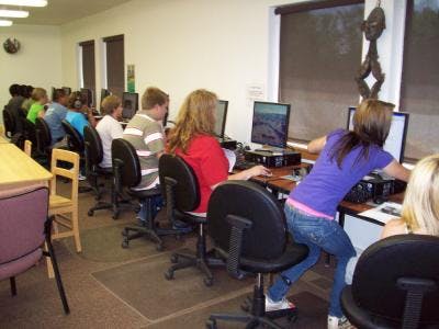 A classroom with students working at computers.