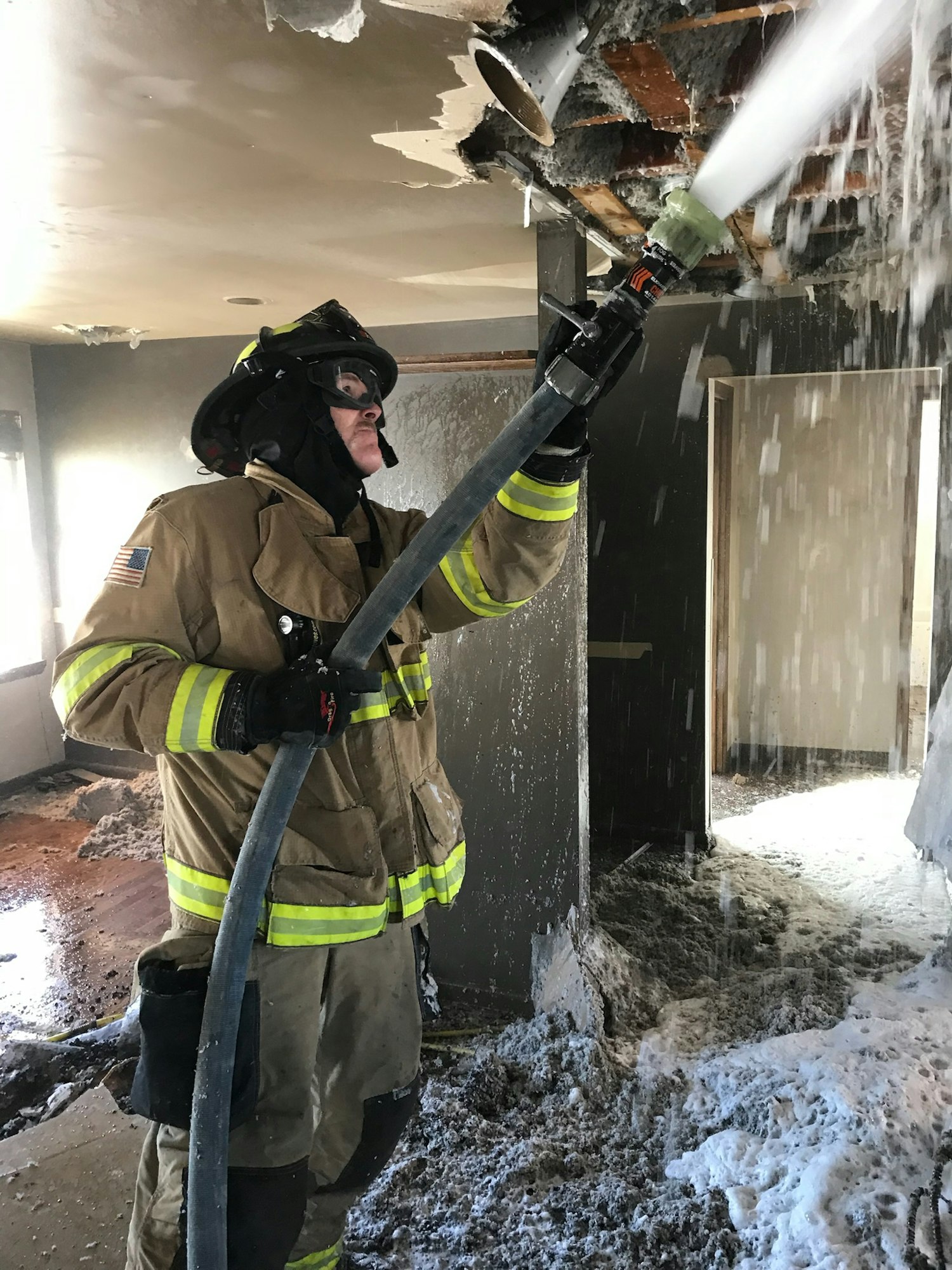 May contain: fireman spraying water inside a building