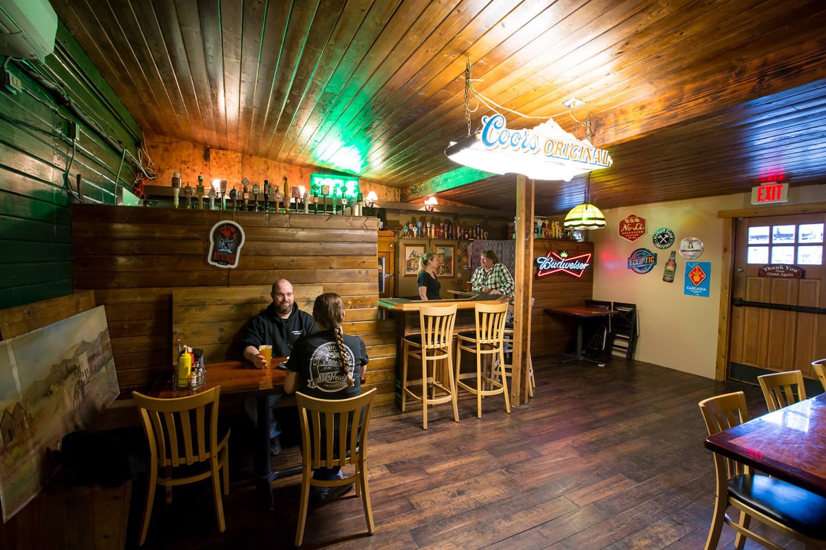 May contain: wood, pub, indoors, interior design, architecture, building, restaurant, chair, furniture, hardwood, dining table, table, and person
