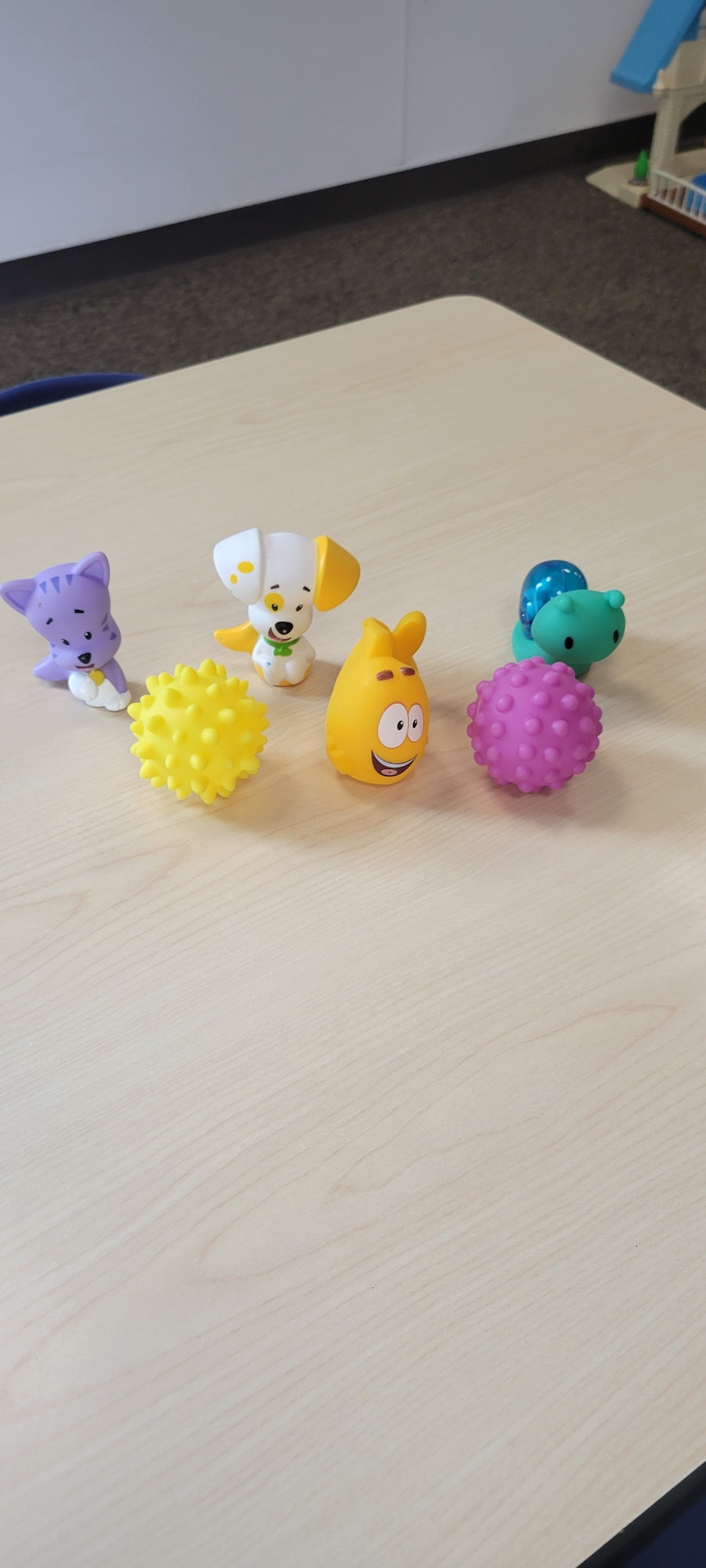 Colorful rubber toys on a wooden surface.