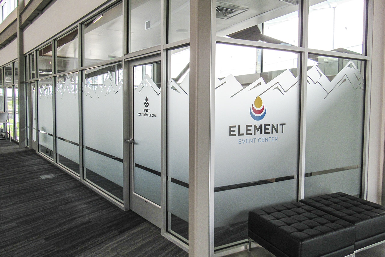 Glass doors to a conference room with a frosted design and "Element Event Center" branding, plus a bench.