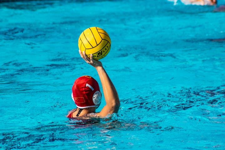 May contain: water, ball, sport, volleyball, volleyball (ball), person, clothing, hat, leisure activities, water sports, cap, pool, and swimming pool