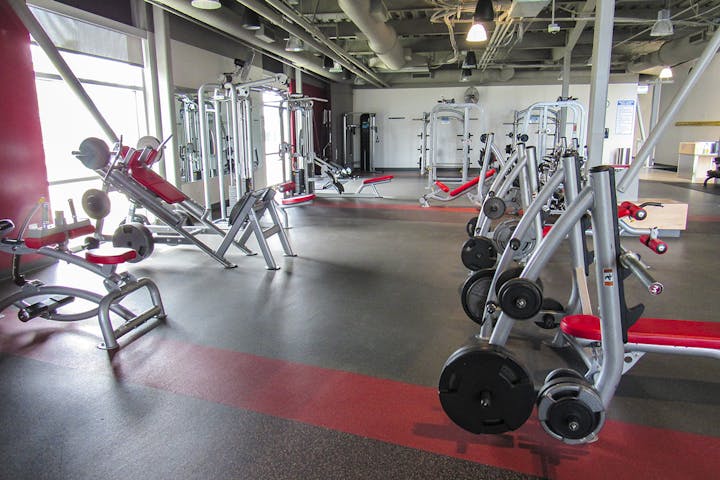 A well-equipped gym with various exercise machines and weights.