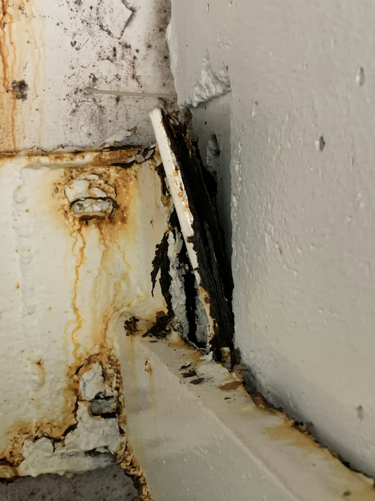 Rust and corrosion on metal surfaces with peeling paint.