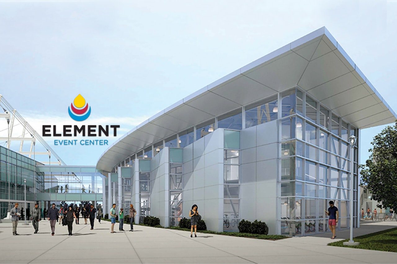 Modern event center with glass walls and people walking around.