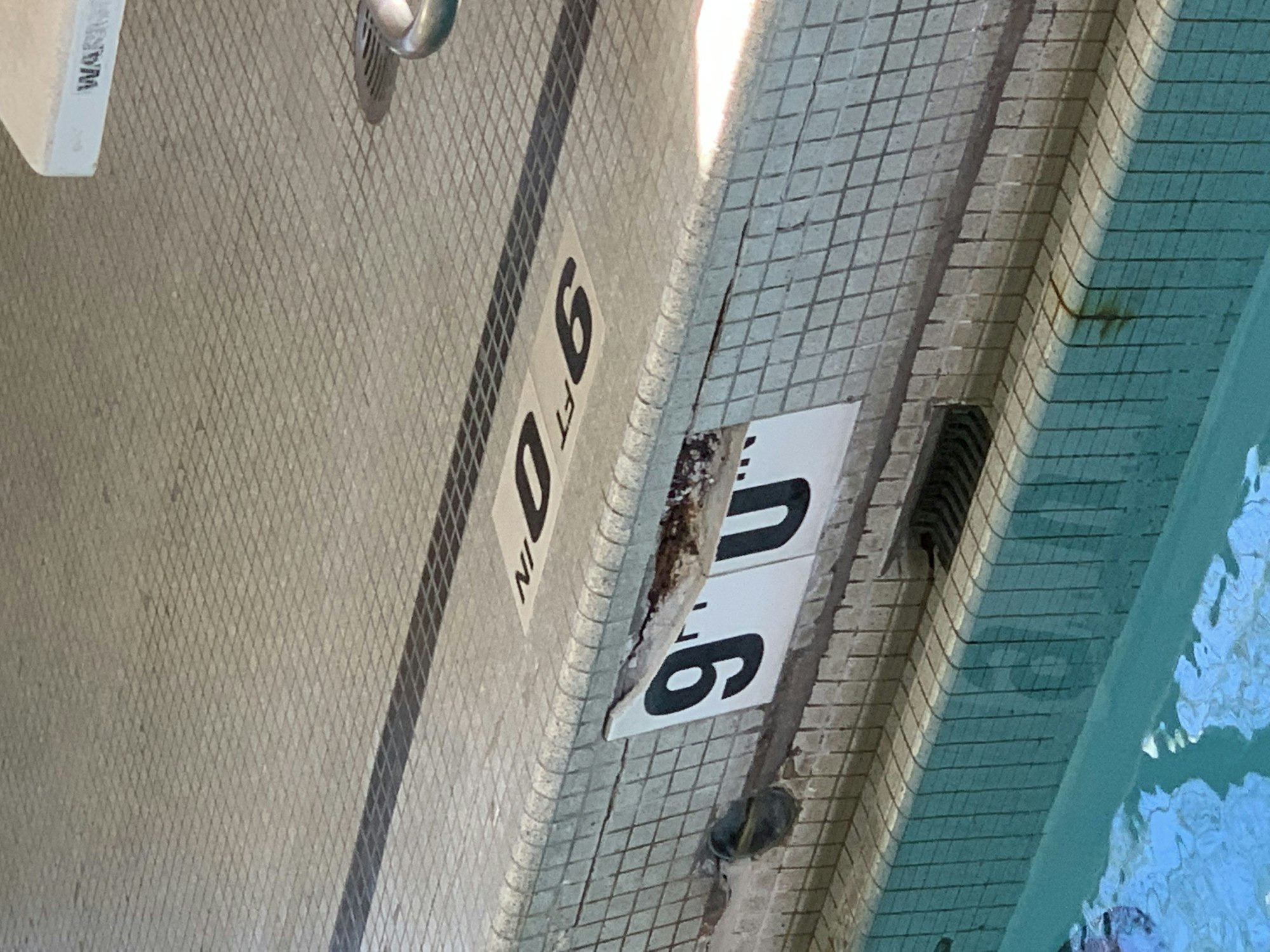 Swimming pool edge showing "9.0 FT" depth marker.