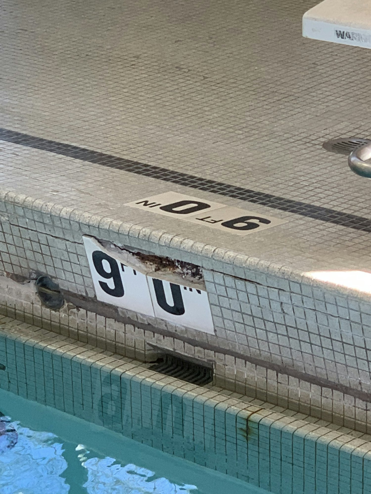Swimming pool edge showing "9.0 FT" depth marker.