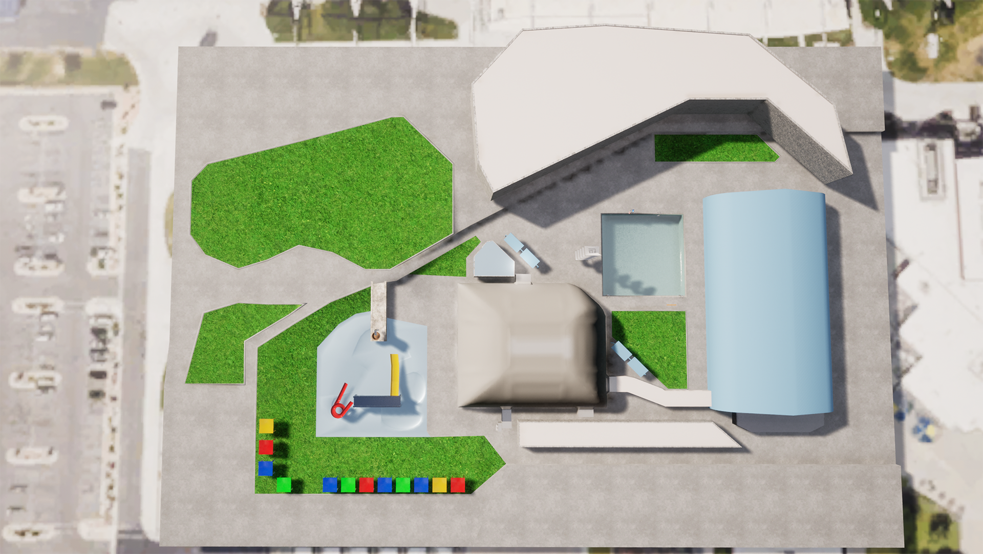 An aerial view of a complex with buildings, green spaces, a small play area with colored blocks, and a pool.