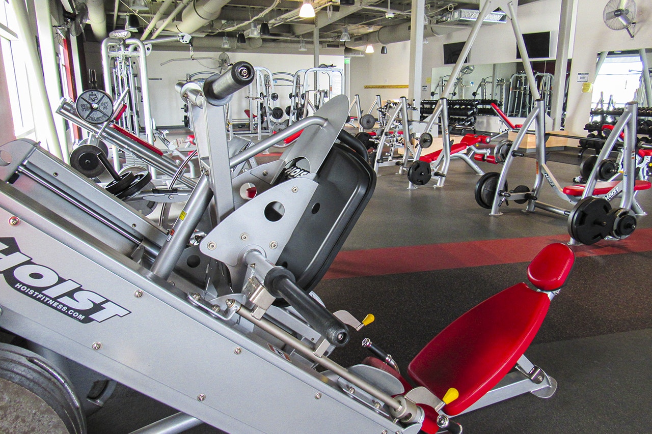 A gym with various exercise machines and equipment.