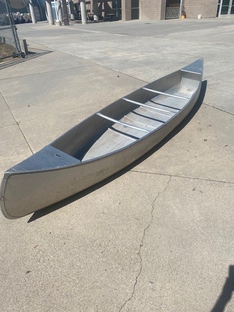 An overturned canoe on a concrete surface.