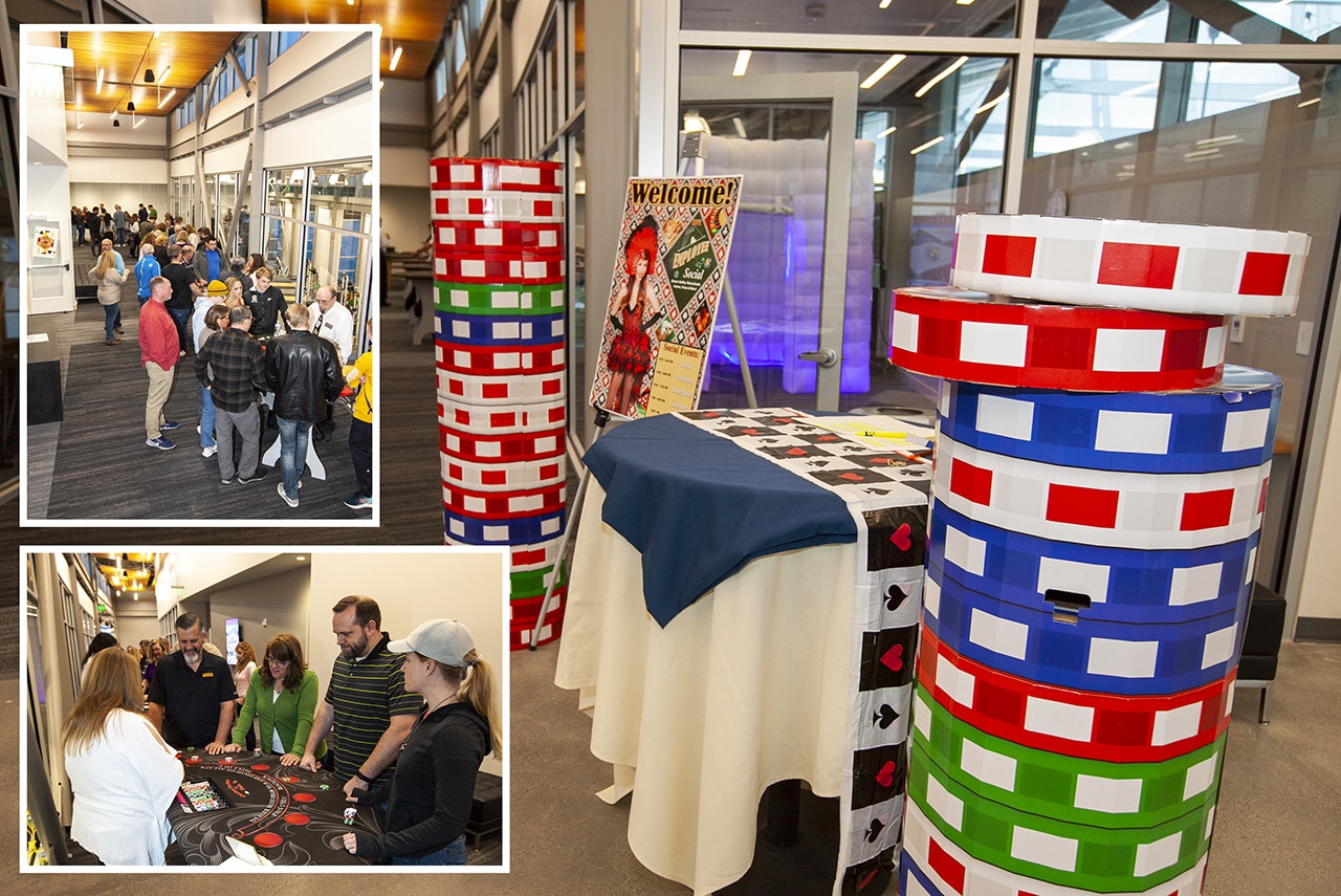 Event with casino-themed decorations: oversized poker chips, people socializing, and engaging in a card game.