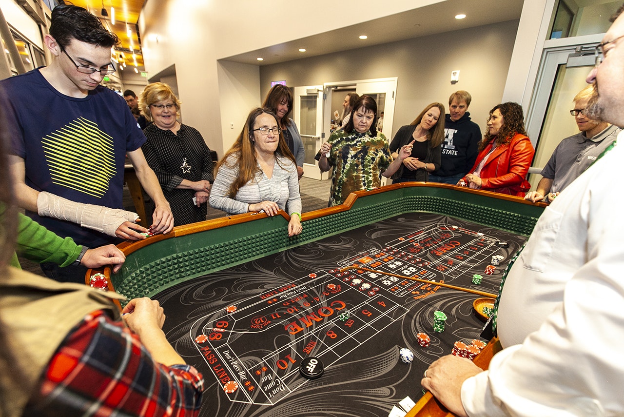 People gathered around a craps table, engaged in a dice game.