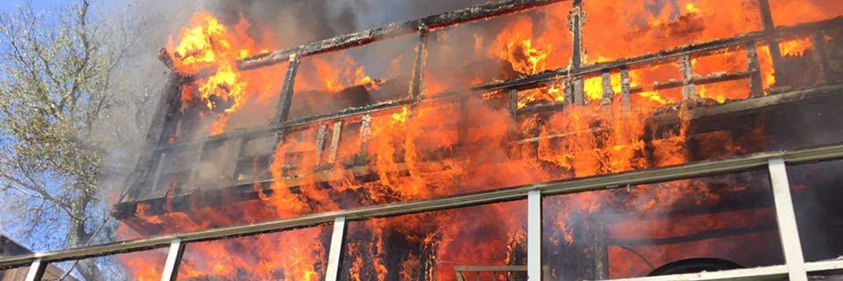 A building engulfed in flames, with smoke billowing into the sky.