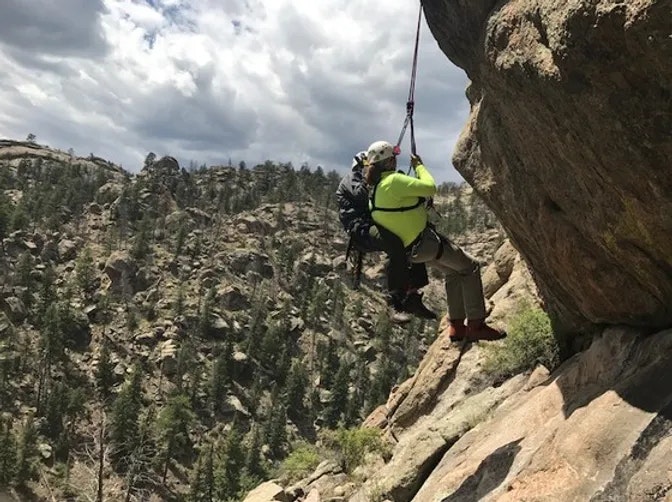 Member hanging off Cliff with rope