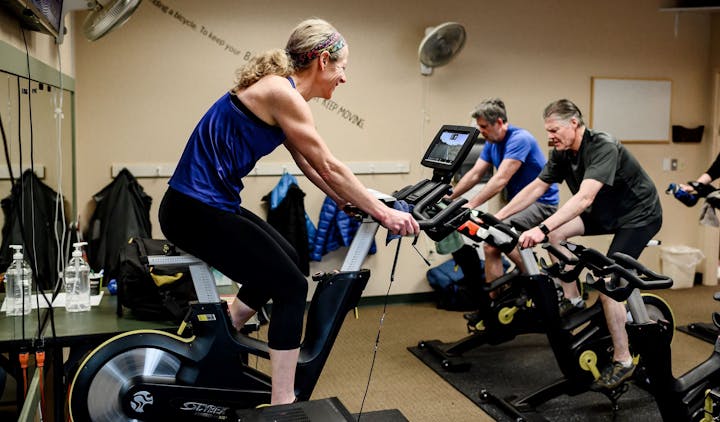 People using exercise bikes in a gym class.