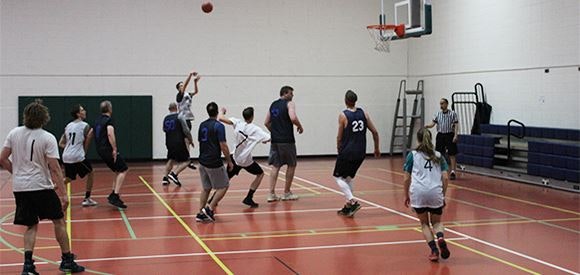 People playing basketball in an indoor court.