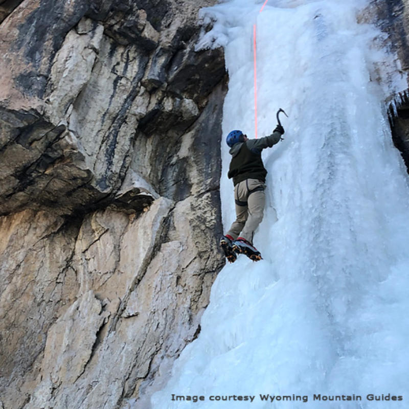 Photo of a person climbing a wall of ice