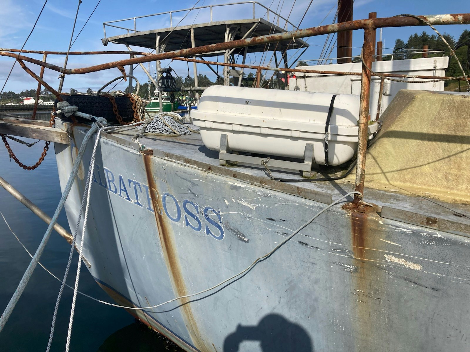 Close-up of a boat named "Albatross," with rusted rails, ropes, and a lifeboat on board.