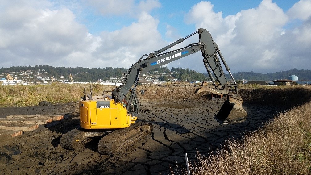 Excavator moving dirt at the South Beach dredge disposal site