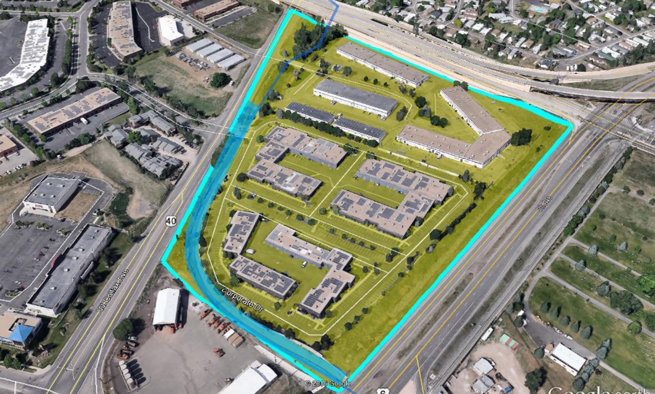 Aerial view of a suburban area with buildings, roads, and highlighted boundary lines.