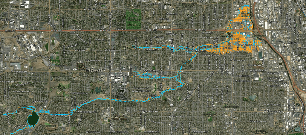 A detailed satellite map showing a city layout with marked waterway and floodplain areas highlighted in blue and orange.