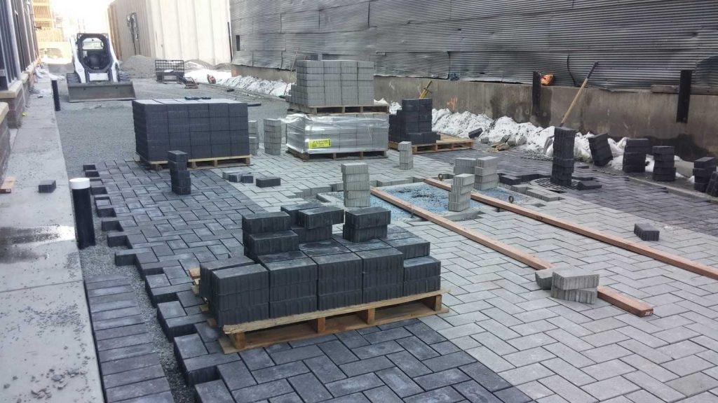 A construction site with paving stones and materials laid out, ready for installation.