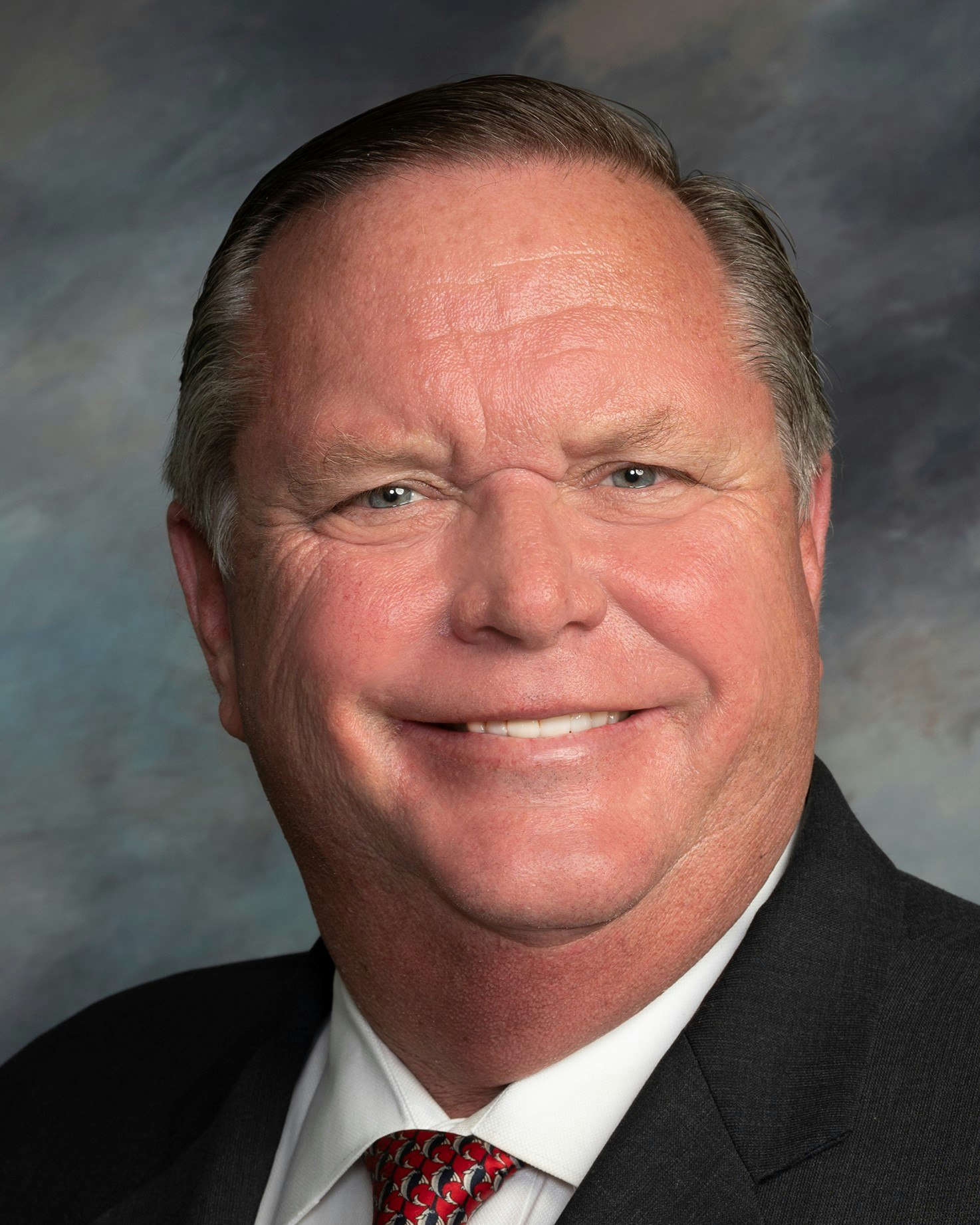 May contain: accessories, formal wear, tie, face, head, person, photography, portrait, adult, male, man, happy, smile, clothing, suit, and necktie