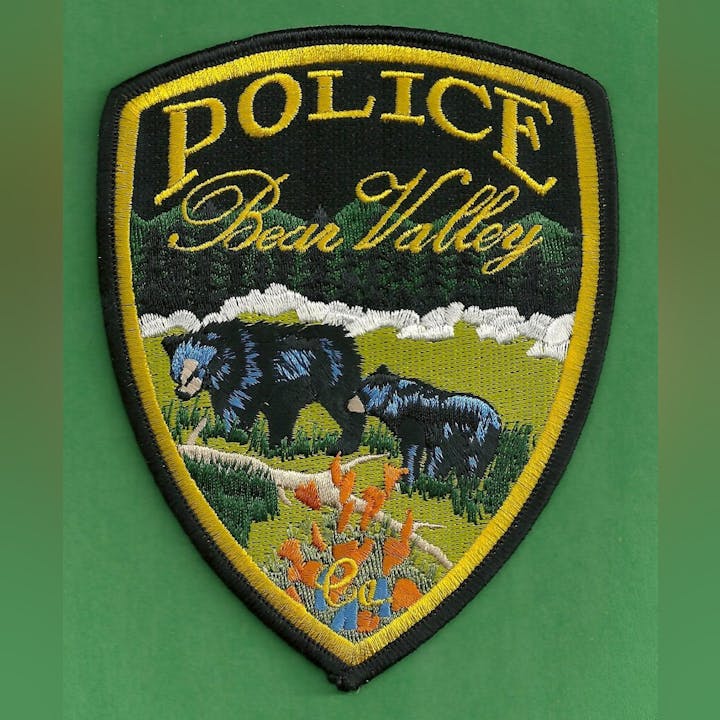 Police patch featuring "Bear Valley" with bears, landscape, and flowers, bordered in yellow.