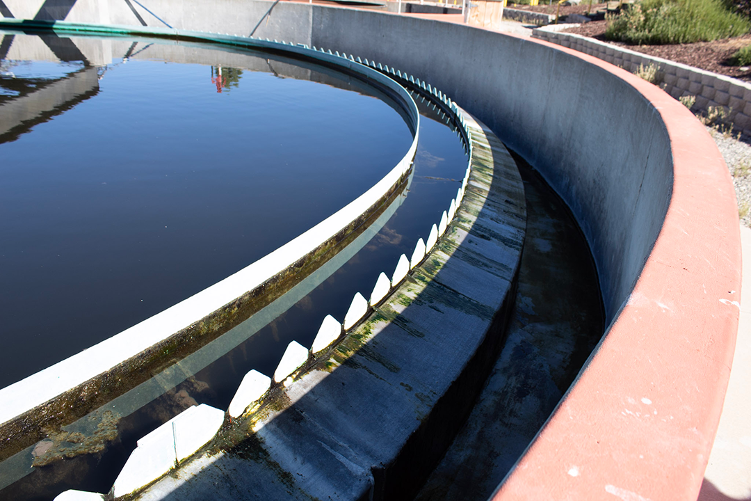 A circular water treatment tank with serrated edges, part of a wastewater facility.