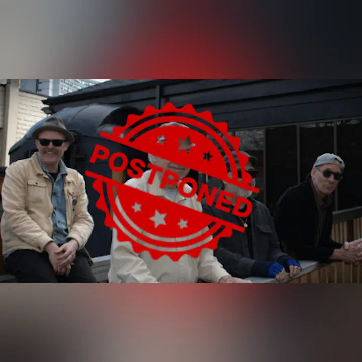 A group of four men sitting together, with a "POSTPONED" stamp overlaying the image.