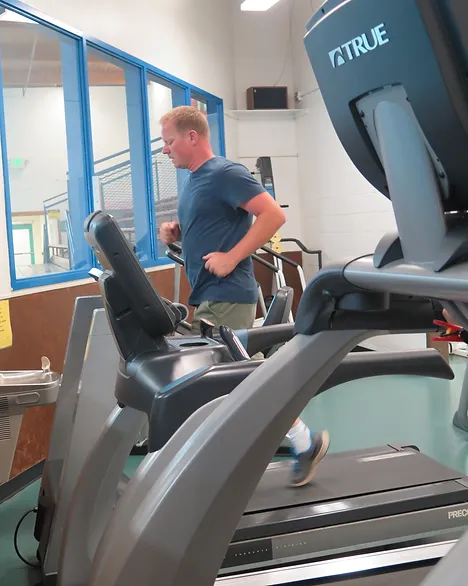 A person running on a treadmill in a gym.