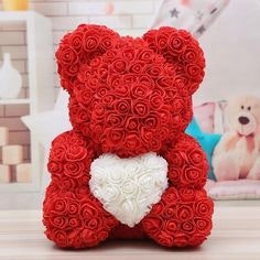 A teddy bear made of red roses holding a white rose heart.