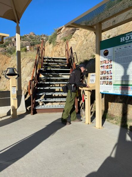 May contain: person, accessories, bag, handbag, gun, weapon, shooting, clothing, footwear, and shoe