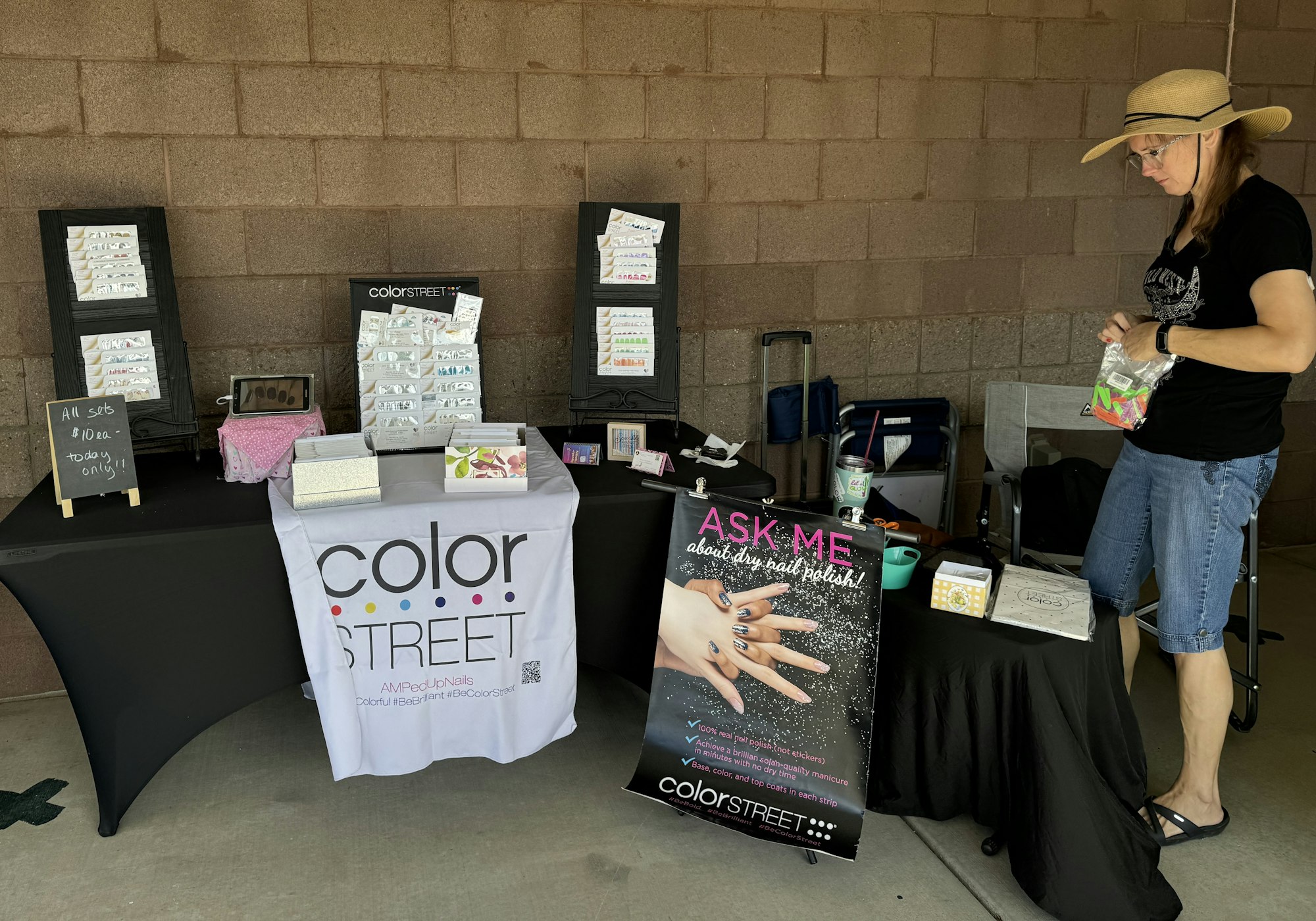 A vendor booth with products and signage for "Color Street," with a person standing beside it.