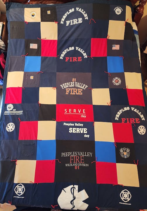 A patchwork quilt featuring logos and text related to Peeples Valley Fire, showcasing community service and firefighting themes.