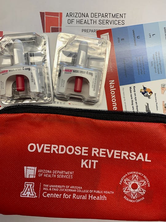 An overdose reversal kit with Narcan nasal spray and instructional material.