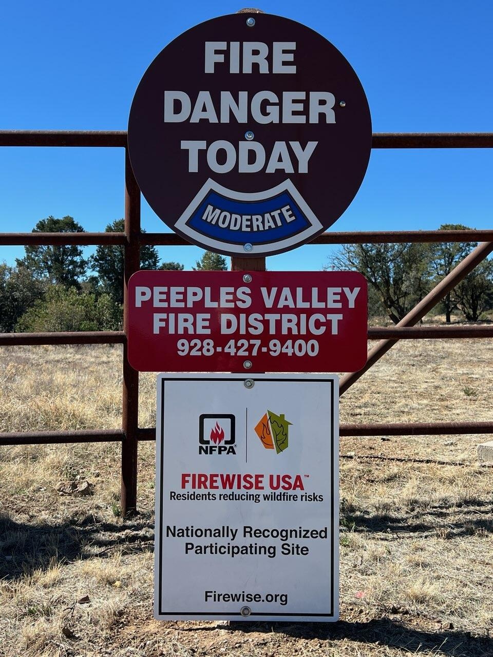 Fire danger signs with "MODERATE" risk level and a Firewise USA recognition for wildfire risk reduction.