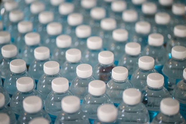 Rows of sealed water bottles with white caps.