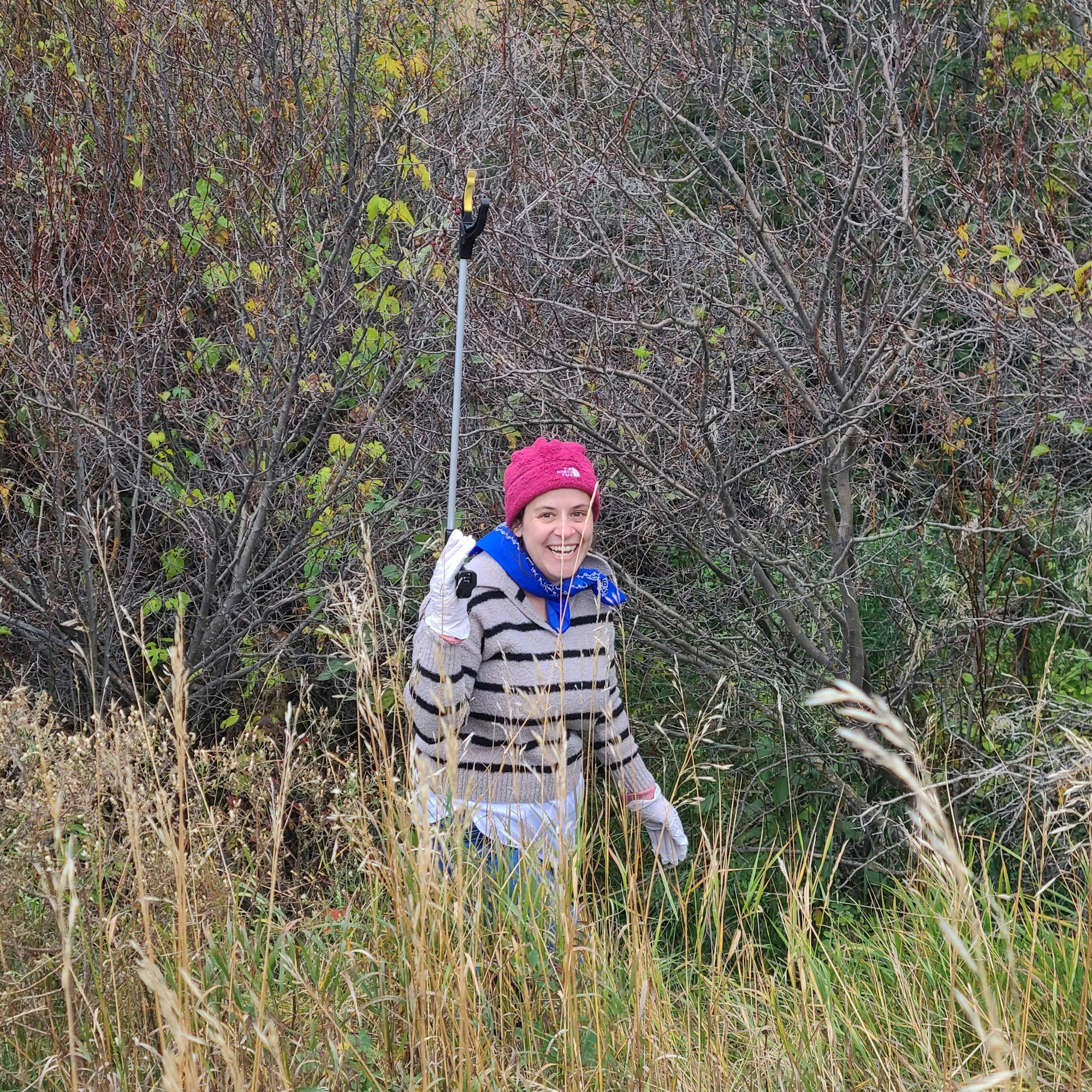 May contain: face, head, person, photography, portrait, plant, vegetation, grass, clothing, hat, cap, nature, outdoors, wilderness, tree, adult, female, woman, land, woodland, field, grassland, coat, baseball cap, glove, and jacket