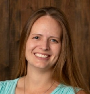 The image features a woman with long hair, smiling against a wooden background. She wears a light blue top.