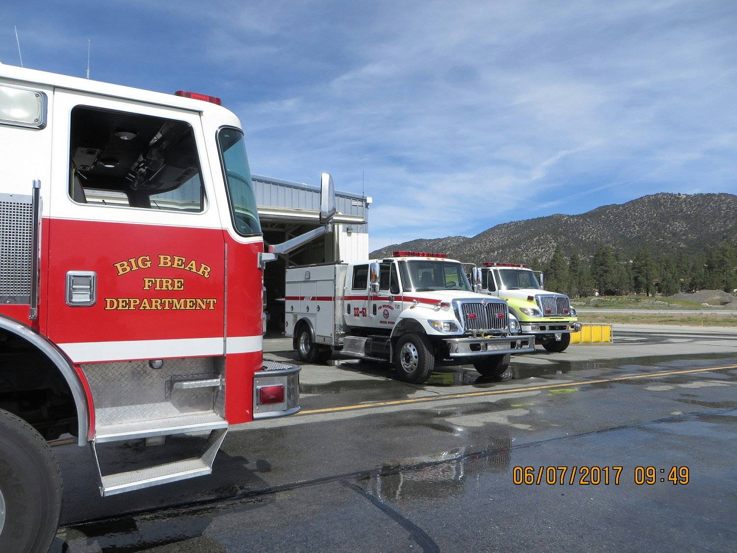 Three fire trucks from Big Bear Fire Department parked outside a station.